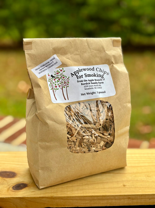 Bag of Applewood Chips for Smoking on a wooden surface with a blurred green background